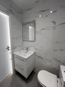 Un baño blanco con lavabo y espejo. en Cap d'Ail - Sea view - 2 bedrooms 3 beds - Rotterdam, en Cap d'Ail 15 fotos más