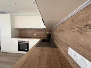 Una cocina con gabinetes blancos y una encimera de madera. en Cap d'Ail - Sea view - 2 bedrooms 3 beds - Rotterdam, en Cap d'Ail