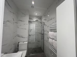 y baño con ducha y paredes de mármol blanco. en Cap d'Ail - Sea view - 2 bedrooms 3 beds - Rotterdam, en Cap d'Ail