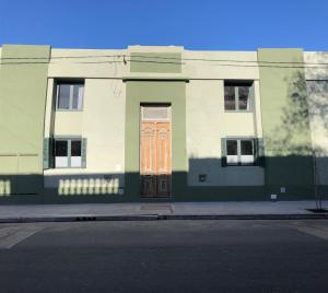 Azul en Lavalle 6 في أزول: مبنى أخضر وأبيض بباب بني