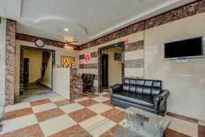 斋浦尔Hotel O Dream Palace的大厅里有一张沙发，墙上有一台电视