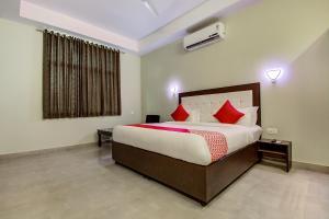 斋浦尔Hotel O Dream Palace的卧室里有一张大床，配有红色枕头