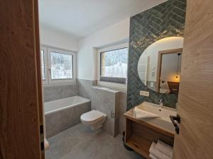 a bathroom with a tub and a toilet and a sink at Lake View Lodge in Flachau +76 photos