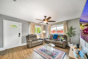 a living room with a couch and a ceiling fan at Relax at Serenity Heated Pool Spa BBQ Near Beach in Palm Beach Gardens