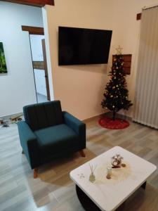 uma sala de estar com uma árvore de Natal e uma cadeira azul em Villa Mastrodomenico em Villa de Leyva