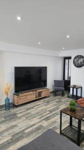 a living room with a large flat screen tv at Le Petit Caporal - Cour Privée - Parking Privée in Bracieux