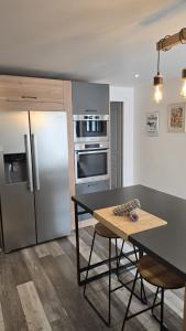 a kitchen with a table and a refrigerator at Le Petit Caporal - Cour Privée - Parking Privée in Bracieux