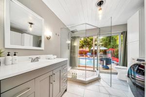 a bathroom with a sink and a glass shower at Relax at Serenity Heated Pool Spa BBQ Near Beach in Palm Beach Gardens