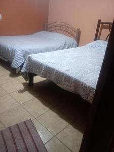 two twin beds in a room with a floor at casa ex hacienda casasano in Cuautla Morelos