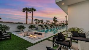 Sleeps 25 2 Luxury Villas w Pool Spa Putting Green Bravo by AvantStay في إنديو: فناء في الهواء الطلق مع مسبح ومدفأة