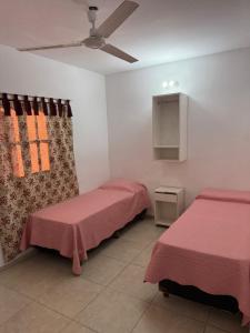 a room with two beds and a ceiling fan at HOTEL REGINA Formosa in Formosa +2 photos