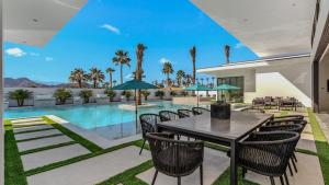 Sleeps 25 2 Luxury Villas w Pool Spa Putting Green Bravo by AvantStay في إنديو: فناء مع طاولة وكراسي وحمام سباحة