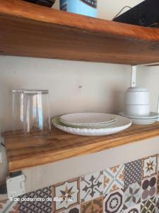 Un plato en un estante de madera con platos encima. en Casa75, en Socorro