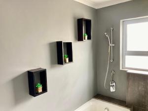 Unit 2 TraversHub Sleeps 6 Self-Catering Group Belhar, CT في Belhar: حمام مع نباتين على الحائط +14 صورة