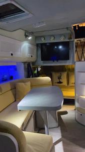 a rv with a table and a couch and a tv at Luxury boat karamba in San Miguel de Abona
