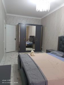 Un dormitorio con una cama grande y un espejo. en Мадрид, en Astana