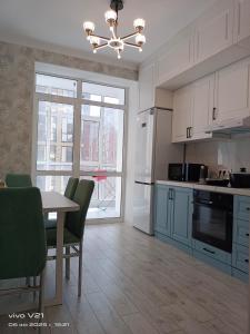 cocina con mesa y sillas y comedor en Мадрид, en Astana
