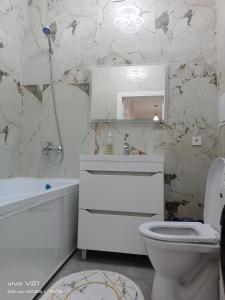 Un baño blanco con inodoro y lavabo. en Мадрид, en Astana