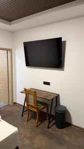 a table with a chair and a television on a wall at Hotel Rosengarten in Frankfurt/Oder
