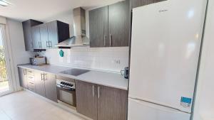a kitchen with wooden cabinets and a white refrigerator at Villa Azul Mar Menor in Torre-Pacheco