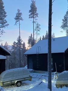 een met sneeuw bedekt gebouw met een auto voor het gebouw bij Villa Blueberry in Kolari