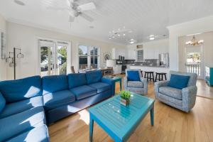 a living room with a blue couch and a table at Surfer Dog l Beachfront Pool l Includes Beach Chairs and Bikes in Inlet Beach