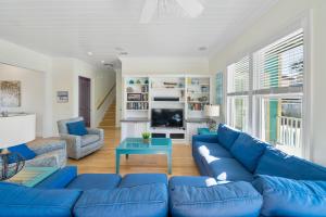 a living room with a blue couch and a table at Surfer Dog l Beachfront Pool l Includes Beach Chairs and Bikes in Inlet Beach