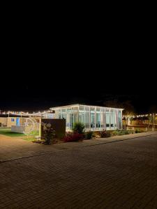 Un gran edificio blanco con luces en la noche. en Alawadhi Farm استراحة العوضي, en Ras al Khaimah
