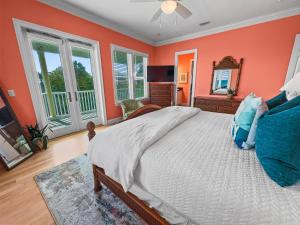 a bedroom with orange walls and a bed and a mirror at Surfer Dog l Beachfront Pool l Includes Beach Chairs and Bikes in Inlet Beach +57 photos