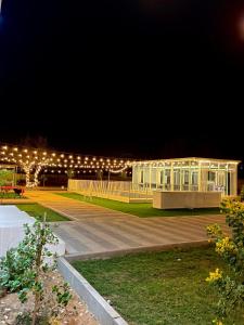 un edificio se ilumina por la noche con luces en Alawadhi Farm استراحة العوضي, en Ras al Khaimah