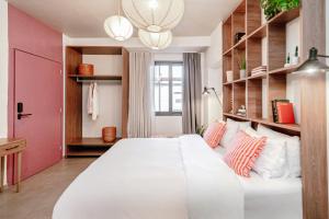 Dogpound Hotel في أثينا: سرير أبيض كبير في غرفة مع رفوف