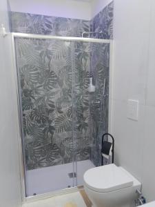 een badkamer met een douche, een toilet en een douchegordijn bij B&b Carlotta in Pozzuoli