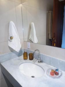 a bathroom counter with a sink and a mirror at Chalé Colibri in Vale do Capao