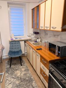 a kitchen with a blue chair and a microwave at Ru apartment in Craiova