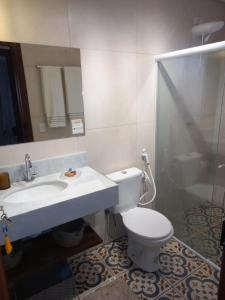 een badkamer met een toilet, een wastafel en een spiegel bij Chalé Colibri in Palmeiras +22 foto's