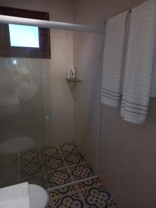 een badkamer met douche, toilet en raam bij Chalé Colibri in Palmeiras