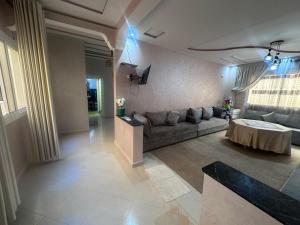 una sala de estar con un sofá y una mesa en appartement luxe, en Berkane