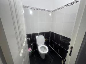 Un baño con inodoro y una pared de azulejos blancos y negros. en appartement luxe, en Berkane 32 fotos más