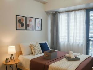 a bedroom with a large bed with a window at Makati Business District Prime Accommodations in Manila +39 photos