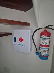 un estintore accanto a un idrante su un muro di Alojamiento tresdiva a El Astillero