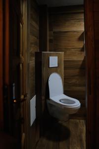 a toilet in a bathroom with a wooden wall at Villa n'Mal in Orllan