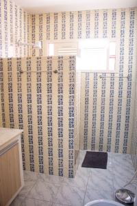 a bathroom with blue and white wallpaper on the wall at Pousada Aconchego Manaíra in João Pessoa