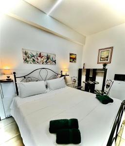 una camera da letto con un grande letto bianco con un cuscino verde sopra di Affittacamere LA CASA DI GIADA a 3 minuti dal casello autostrada di Imola - parcheggio privato e self check-in a Imola