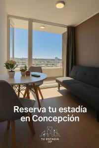 una sala de estar con un sofá y una mesa en la cuidad en las alturas, en Concepción