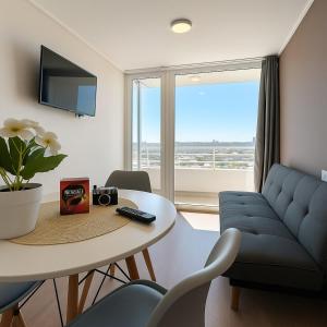 Una sala de estar con una mesa y un sofá azul. en la cuidad en las alturas, en Concepción