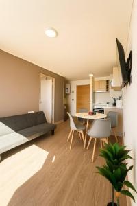 una sala de estar con un sofá y una mesa en la cuidad en las alturas, en Concepción