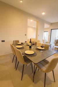 a dining room with a table with chairs and wine glasses at Splendid Mountains View Three Bedroom Apartment in Moka