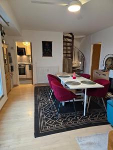 T2 Cosy spacieux Balneo Sauna Parking Noel في ستراسبورغ: مطبخ وغرفة طعام مع طاولة وكراسي حمراء