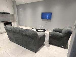 a living room with a couch and a chair at 268 Self-catering Apartments in Swakopmund