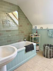 ein Badezimmer mit Badewanne und Waschbecken in der Unterkunft Charming Dog-Friendly Guesthouse in Sidbury + 37 Fotos